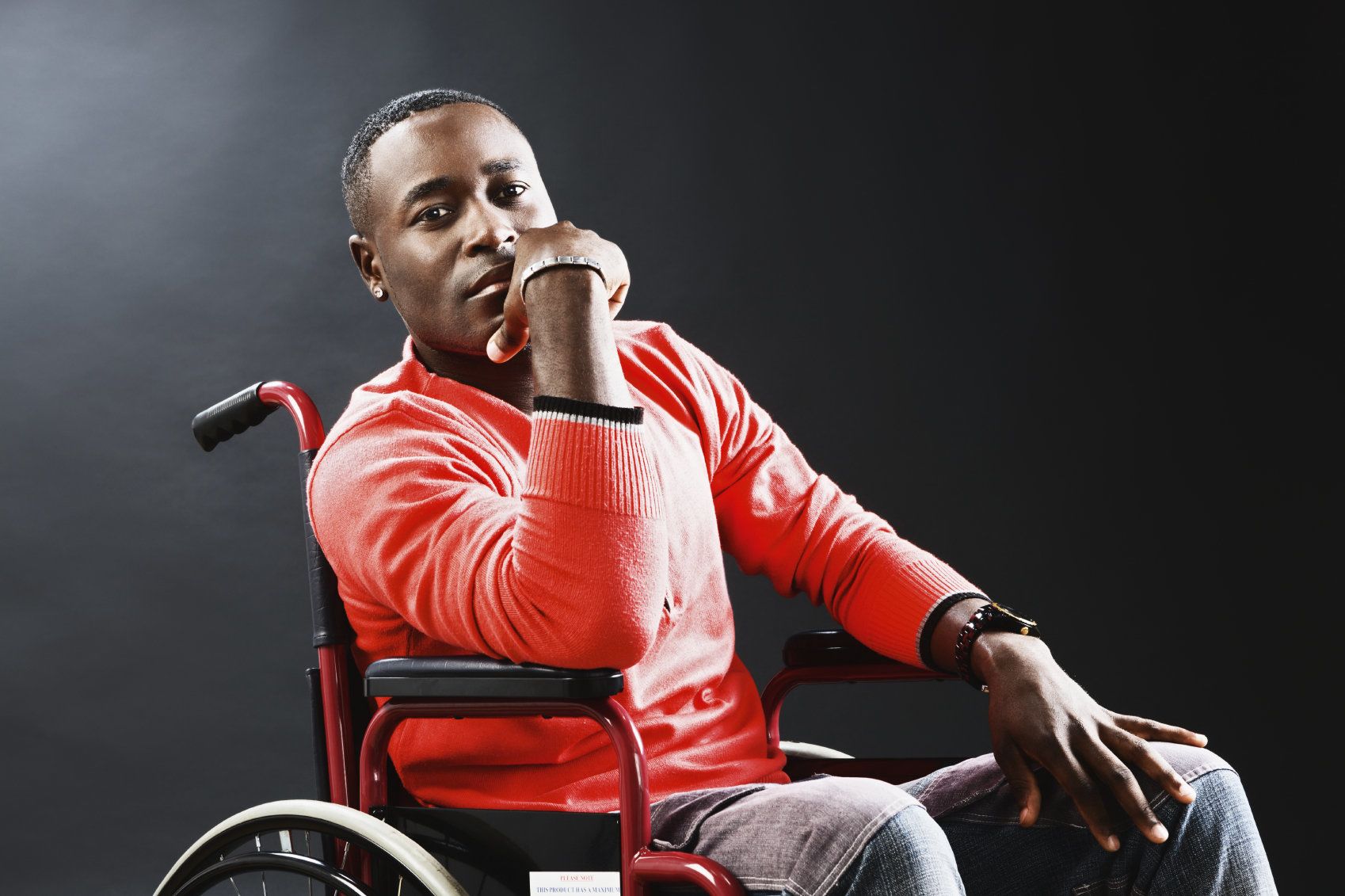 Man in wheelchair holding chin in hand