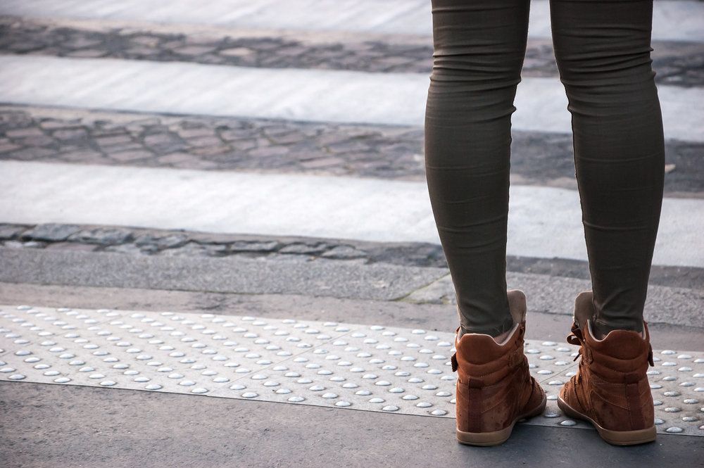 Woman's legs at edge of crosswalk